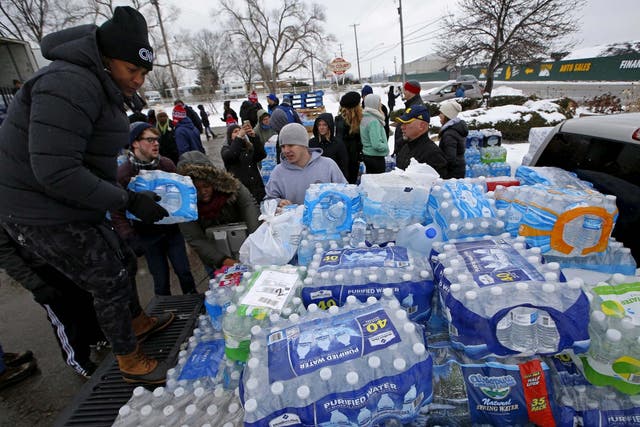 Volunteers distribute bottled water to help combat the effects of the crisis when the city's drinking water became contaminated with dangerously high levels of lead in Flint, Michigan