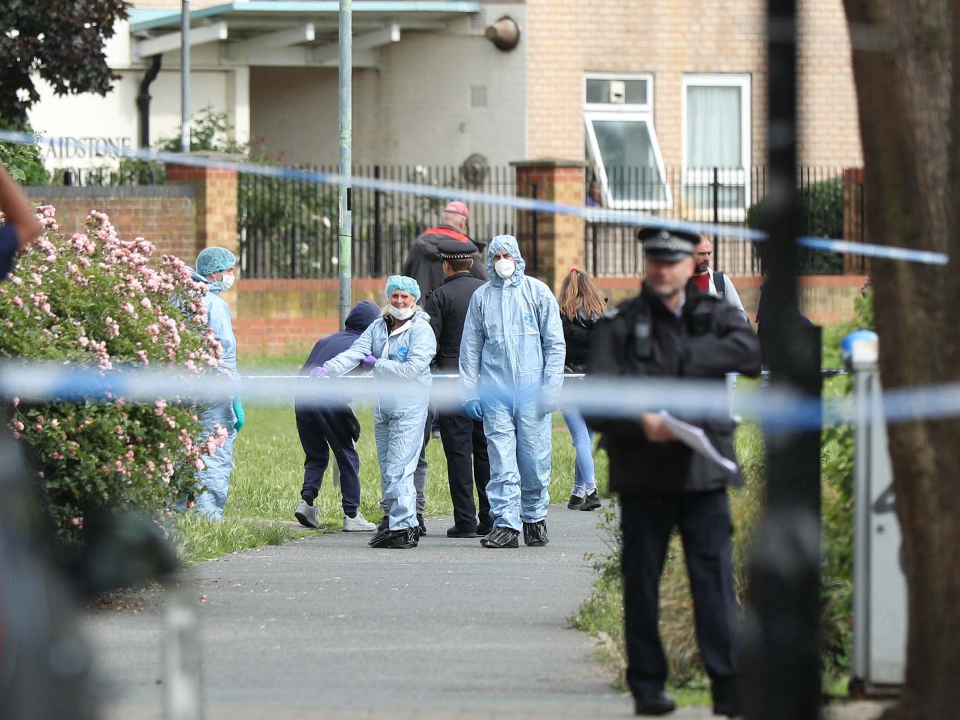 Police and forensics officers at the scene of a stabbing in east London