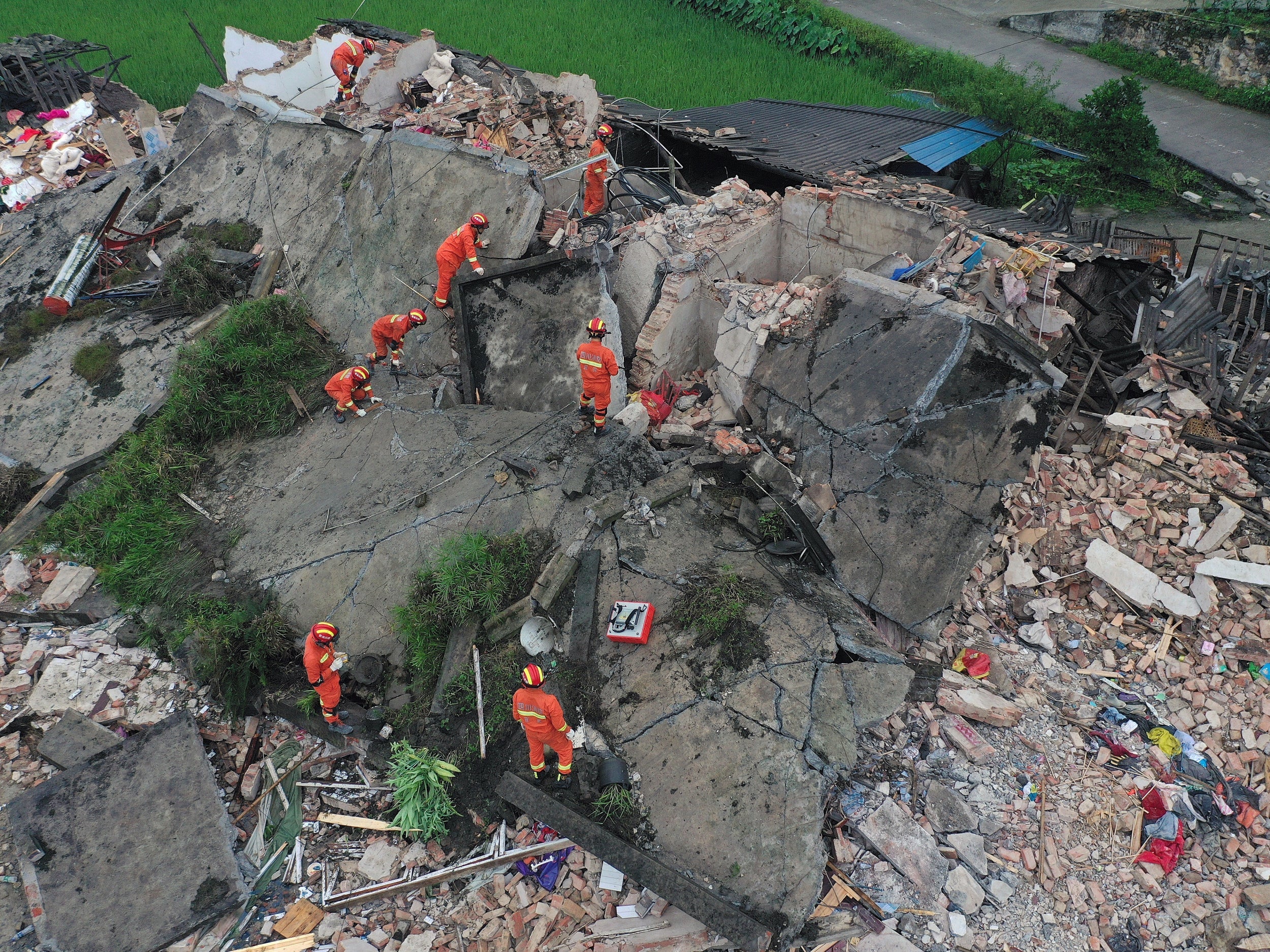 Rescue workers are seen on a collapsed house after earthquakes hit Changning county in Yibin, Sichuan province