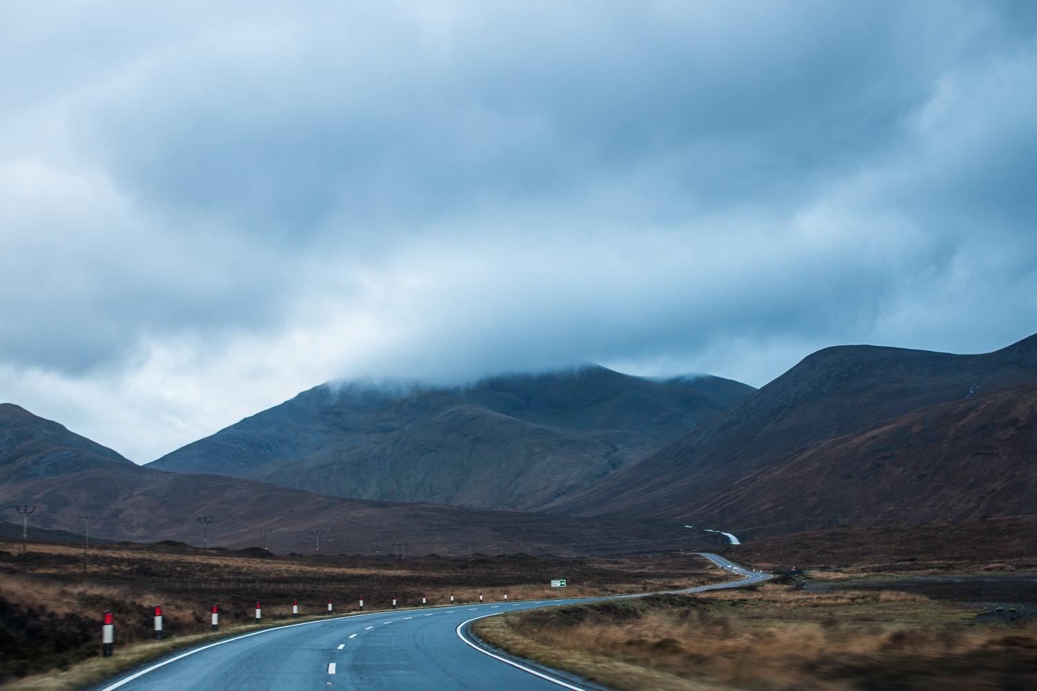 Roads are flanked by misty mountains in the Hebrides