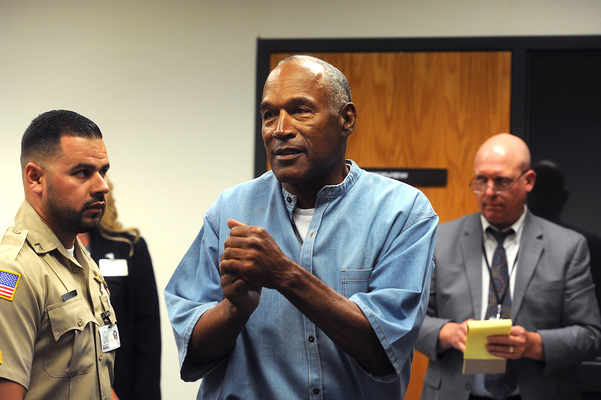 O.J. Simpson (C) reacts after learning he was granted parole at Lovelock Correctional Center July 20, 2017 in Lovelock, Nevada. Simpson is serving a nine to 33 year prison term for a 2007 armed robbery and kidnapping conviction