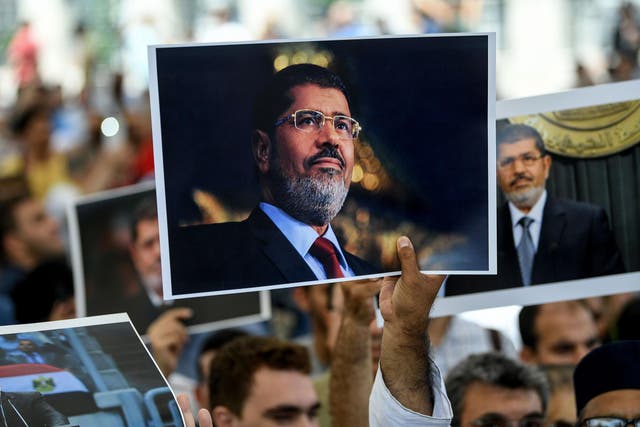 Mourners hold pictures of former Egyptian president Mohamed Morsi during a symbolic funeral ceremony on 18 June 2019 at Fatih mosque in Istanbul