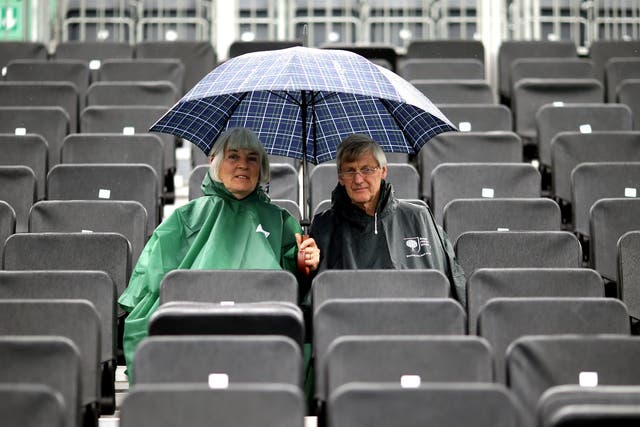 Spectators shelter from the rain during day two of the Fever-Tree Championship at the Queen's Club, London