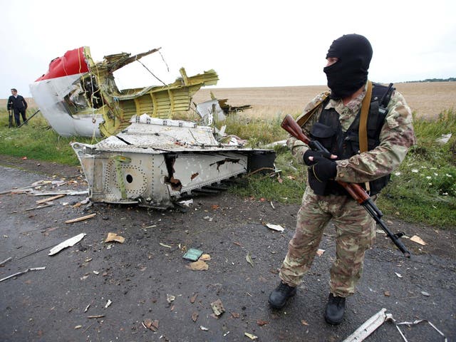 A pro-Russian separatist stands at the crash site of Malaysia Airlines flight MH17