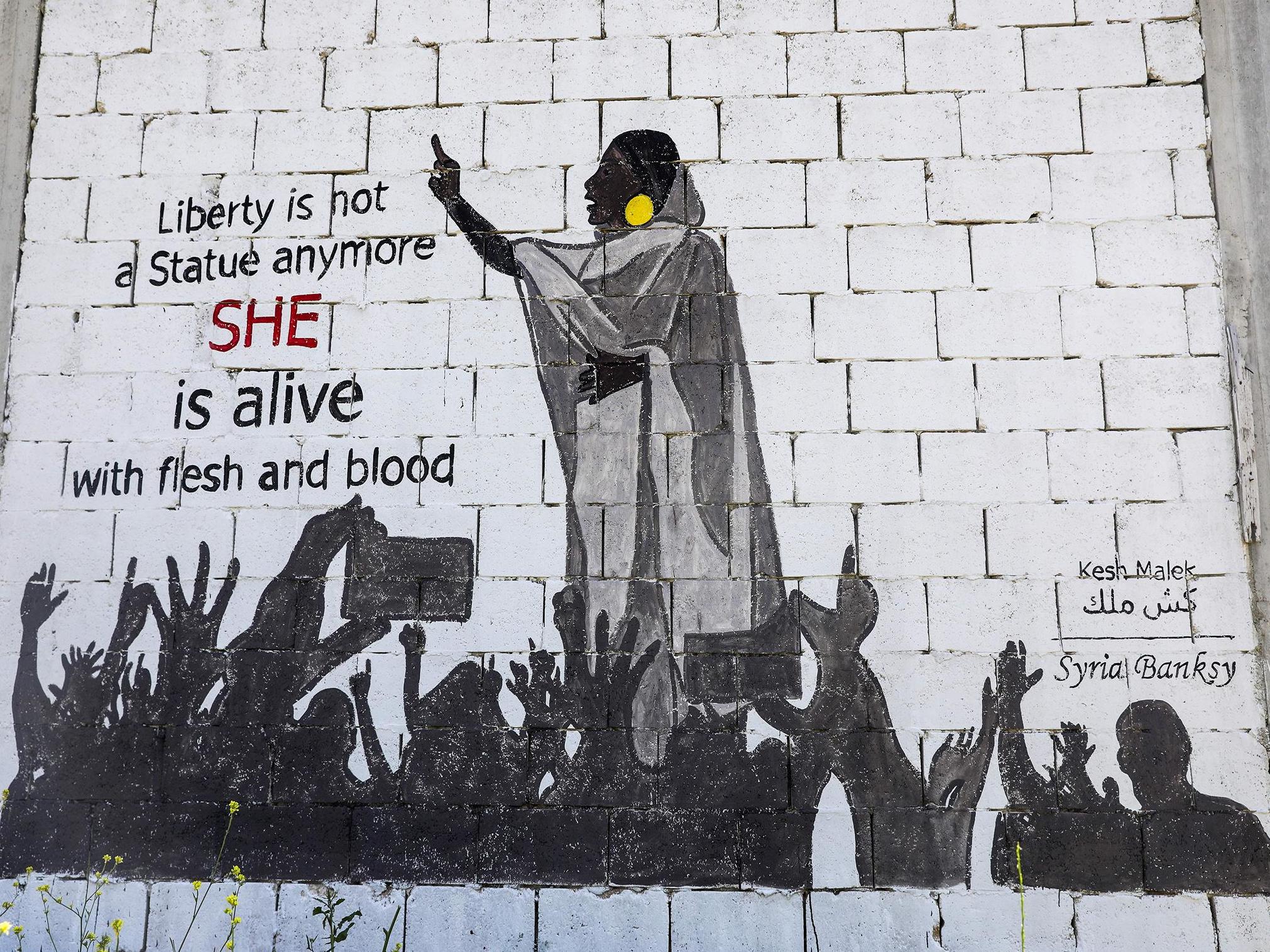 A mural shows protester Alaa Salah leading chants against President Omar al-Bashir
