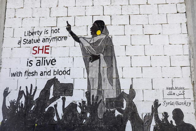 A mural shows protester Alaa Salah leading chants against President Omar al-Bashir