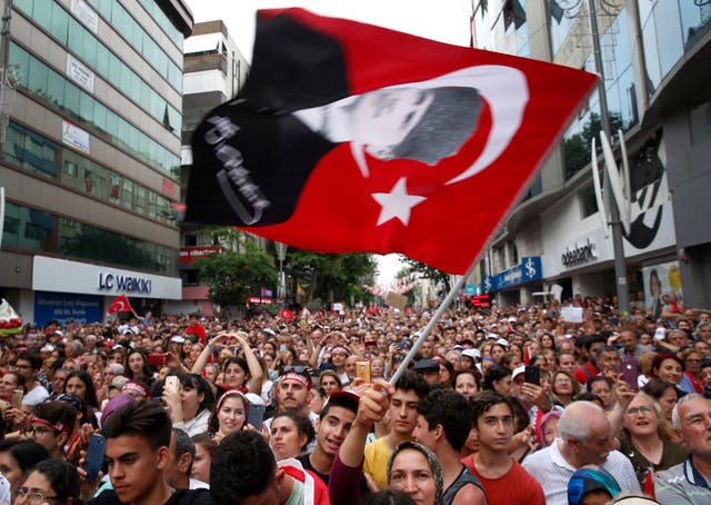 A supporter of Ekrem Imamoglu, candidate of the secular opposition Republican People's Party, or CHP, waves a Turkish flag with a picture of modern Turkey's founder Mustafa Kemal Ataturk, during a rally in Istanbul