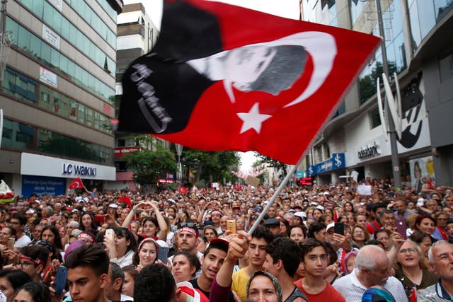 A supporter of Ekrem Imamoglu, candidate of the secular opposition Republican People's Party, or CHP, waves a Turkish flag with a picture of modern Turkey's founder Mustafa Kemal Ataturk, during a rally in Istanbul
