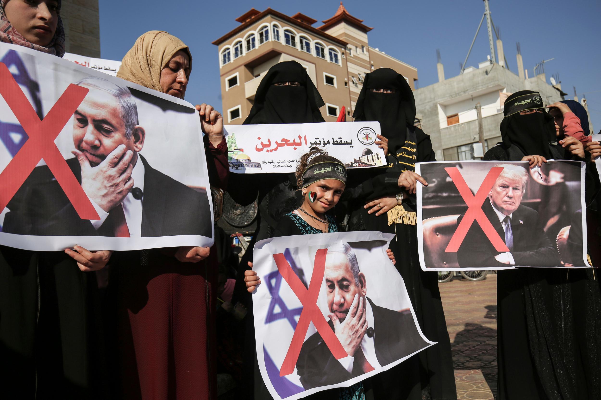 Palestinian female supporters of the Islamic Jihad carry posters of US President Donald Trump and Israeli Prime Minister Benjamin Netanyahu during a protest against the Bahrain economic workshop
