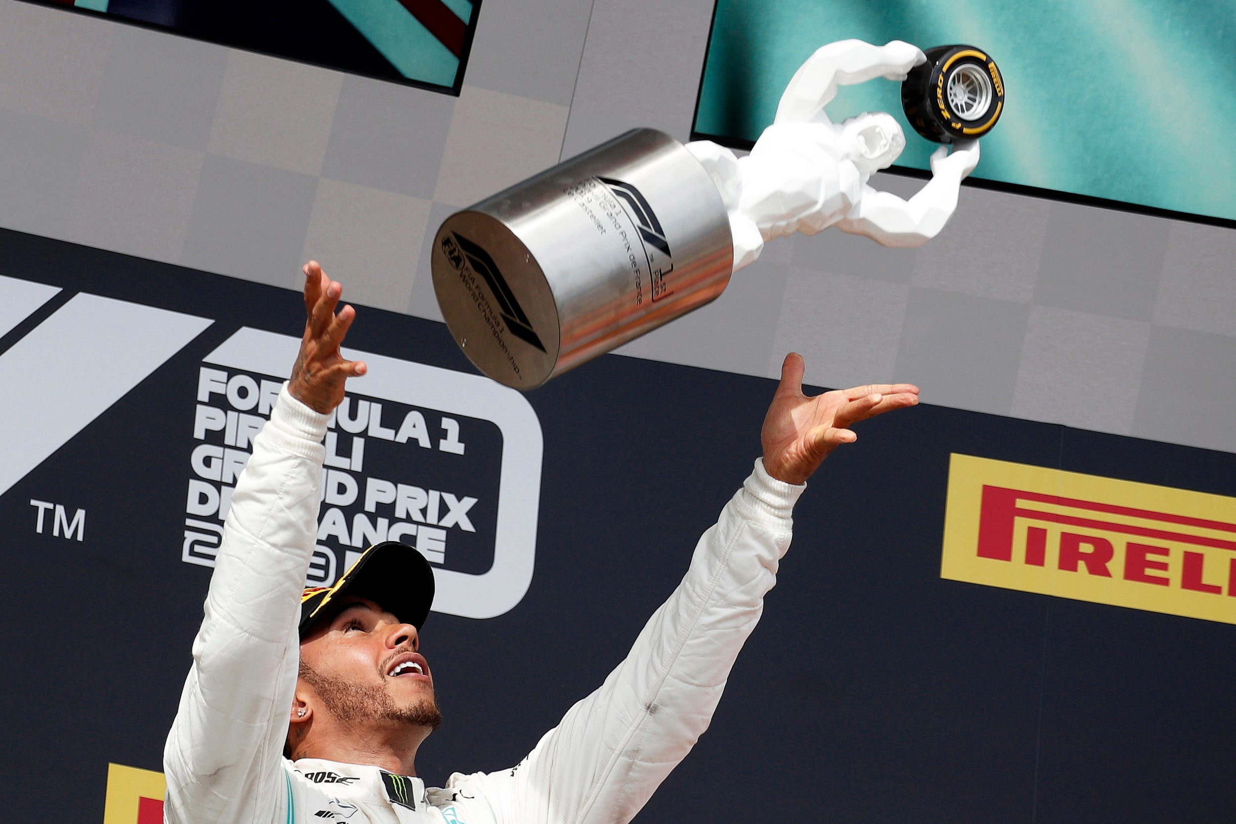 The Brit tosses his latest trophy into the air