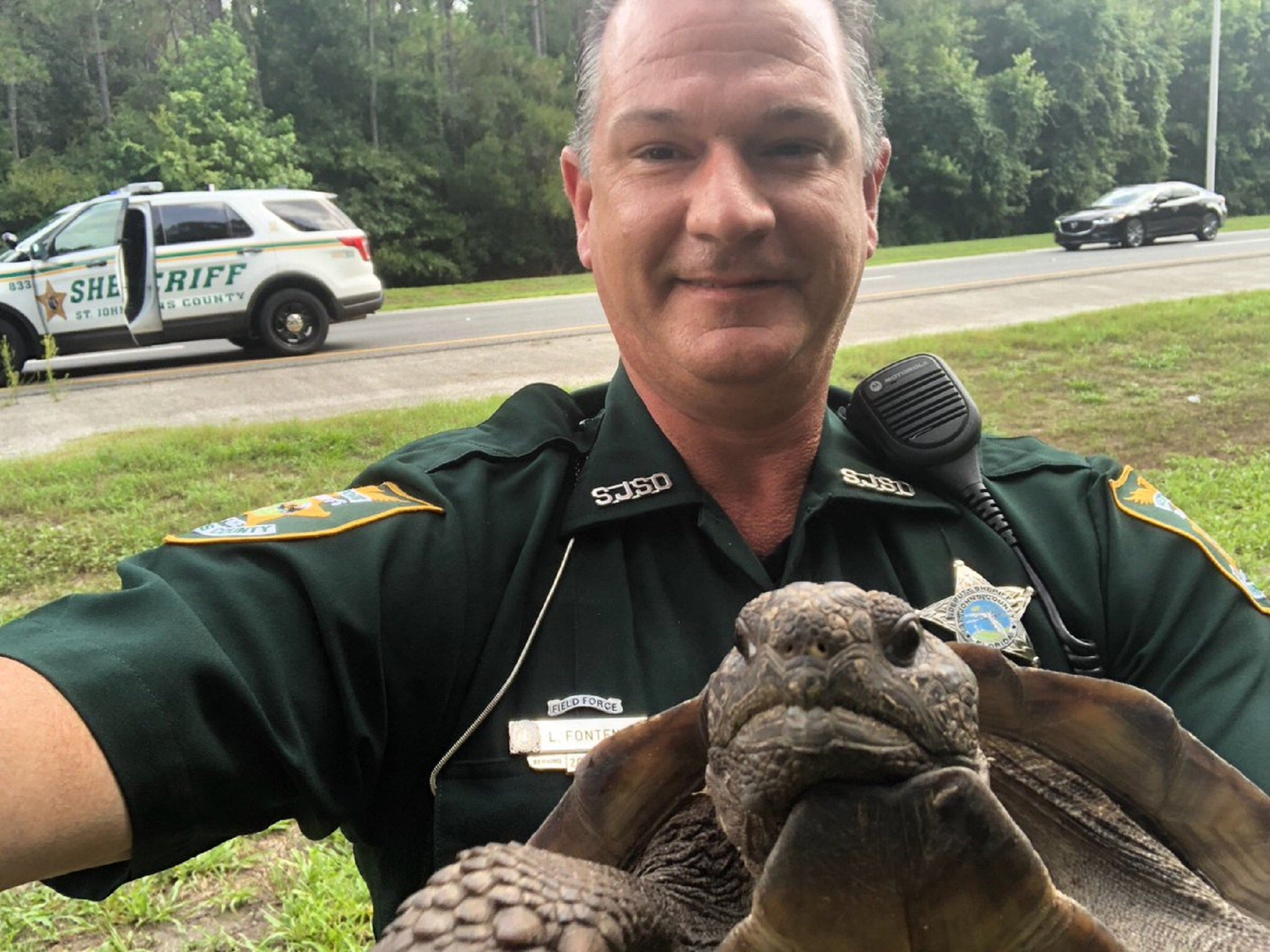 St John’s County Sheriff’s Deputy L Fontenot with the gopher tortoise he detained after it blocked a road in Florida.