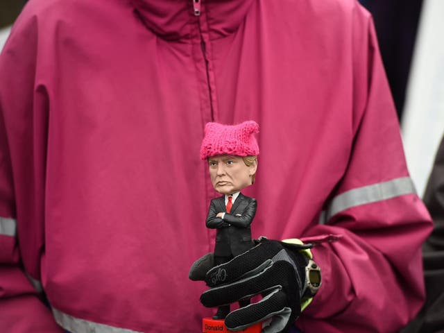 Protester holding Trump doll with knitted hat during 2017 Women's March
