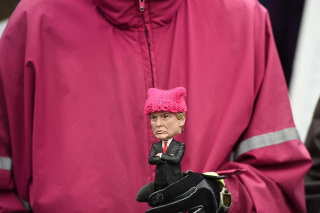 Protester holding Trump doll with knitted hat during 2017 Women's March