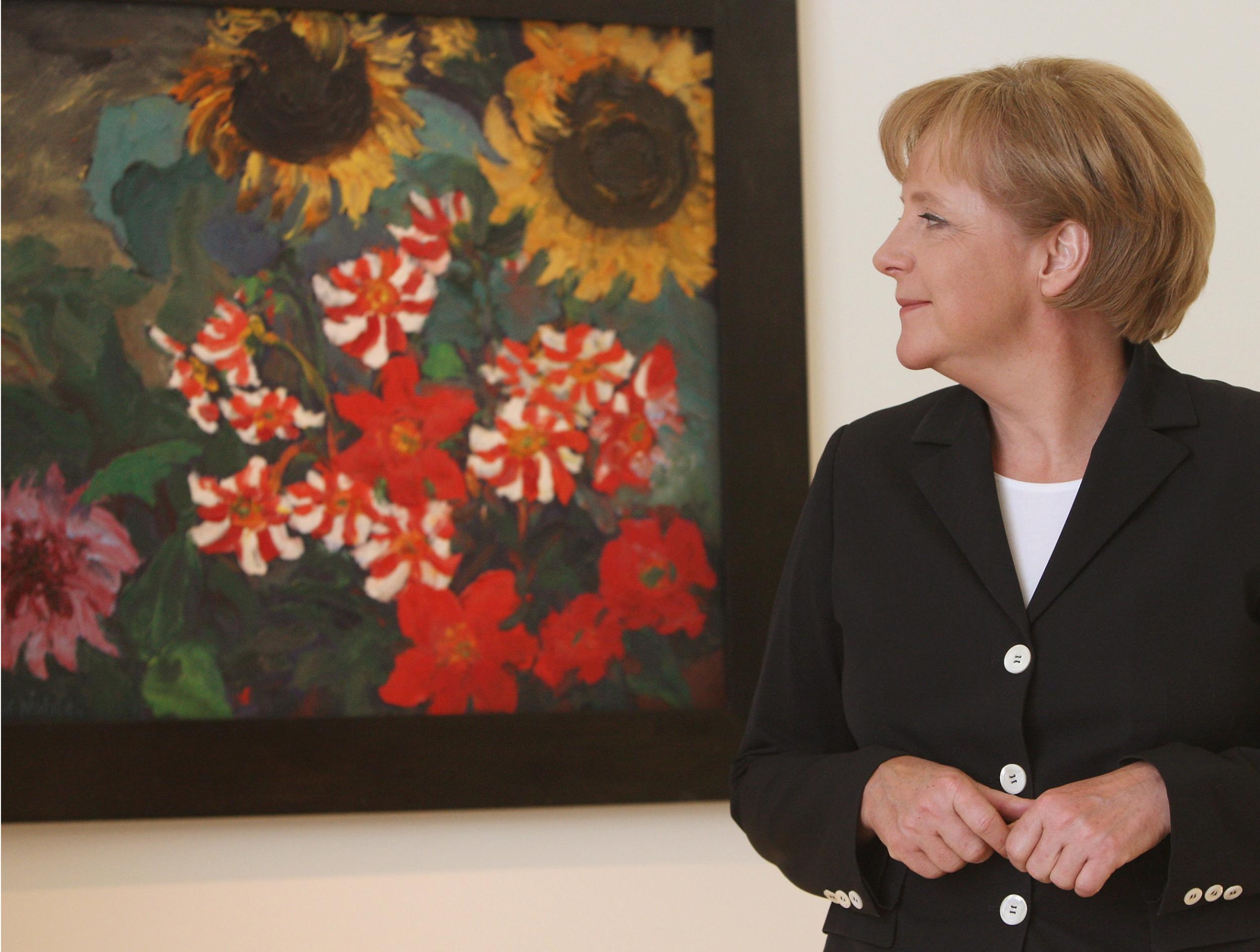 Angela Merkel looks at the painting ‘Dahlias and Sunflowers’ from 1928 by Emil Nolde