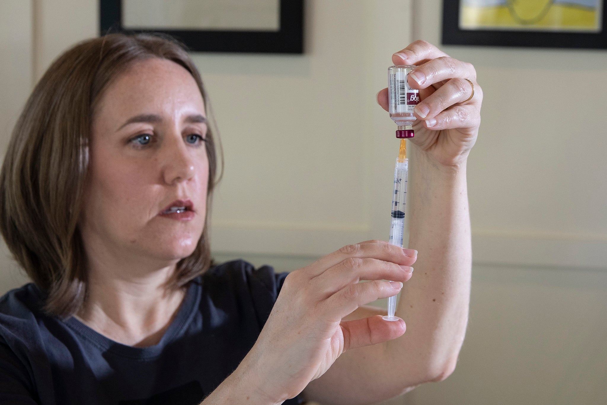 Greenseid draws insulin from a vial to fill a pump cartridge
