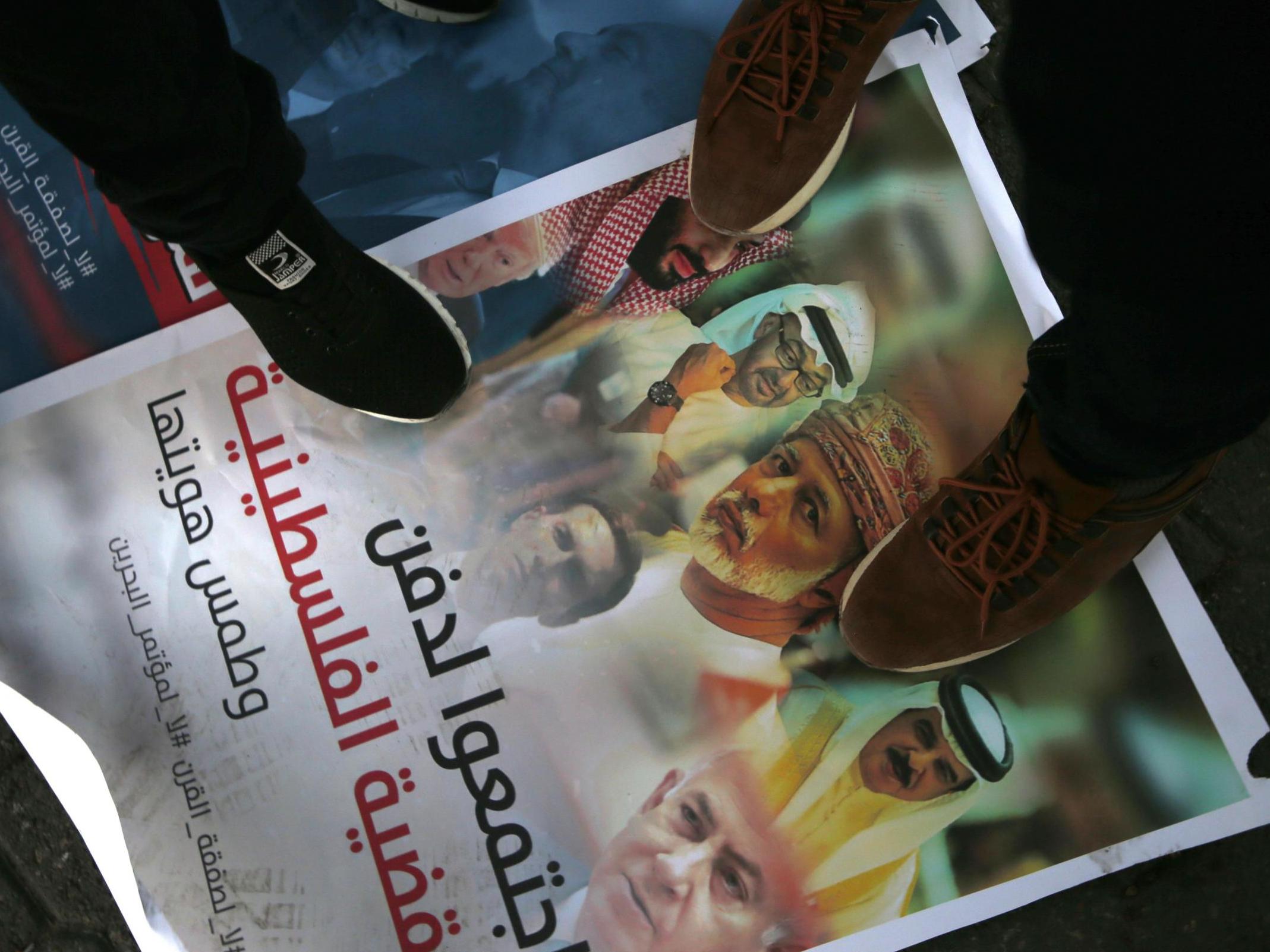 Palestinians step on a placard displaying pictures of Bahraini King Hamad al-Khalifa, Israeli Prime Minister Benjamin Netanyahu, US President Donald Trump and his son-in-law and adviser Jared Kushner, during a protest.