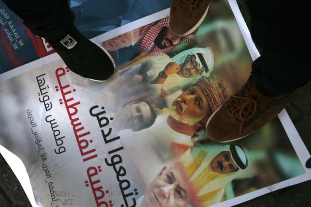 Palestinians step on a placard displaying pictures of Bahraini King Hamad al-Khalifa, Israeli Prime Minister Benjamin Netanyahu, US President Donald Trump and his son-in-law and adviser Jared Kushner, during a protest.