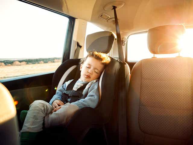 Smiling little boy sitting car in child seat