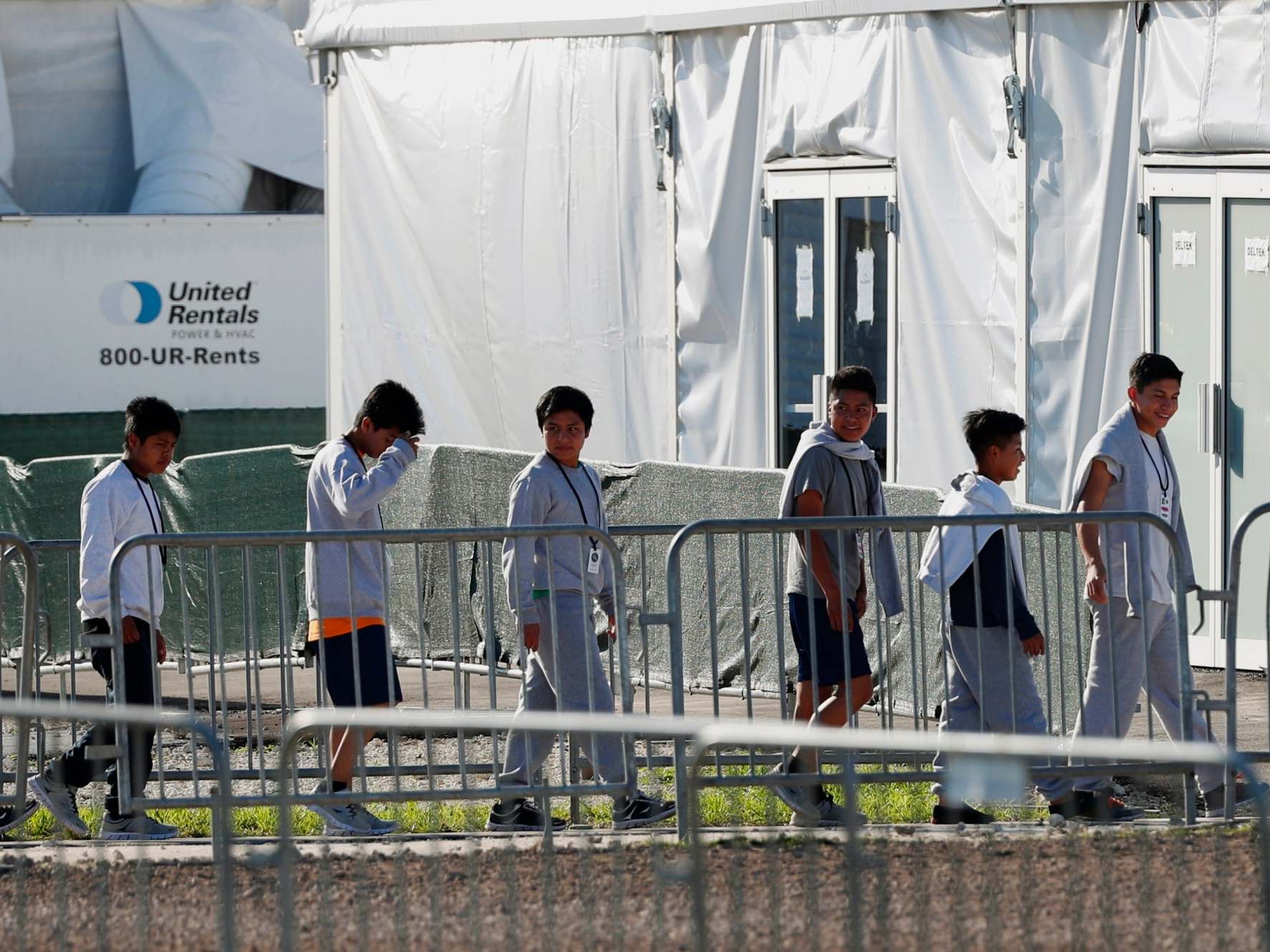Youngsters line up to enter a tent at the Homestead Temporary Shelter for Unaccompanied Children in Homestead, Fla