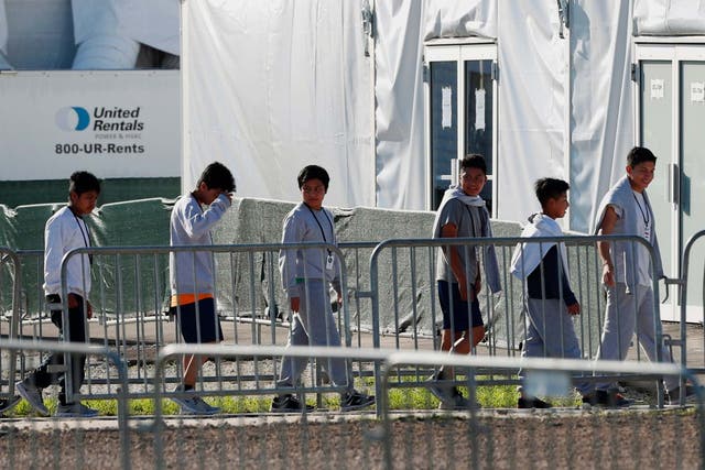 Youngsters line up to enter a tent at the Homestead Temporary Shelter for Unaccompanied Children in Homestead, Fla