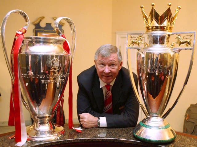 Sir Alex Ferguson with the Champions League and Premier League trophies