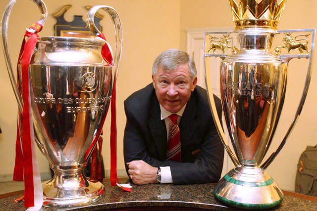 Sir Alex Ferguson with the Champions League and Premier League trophies