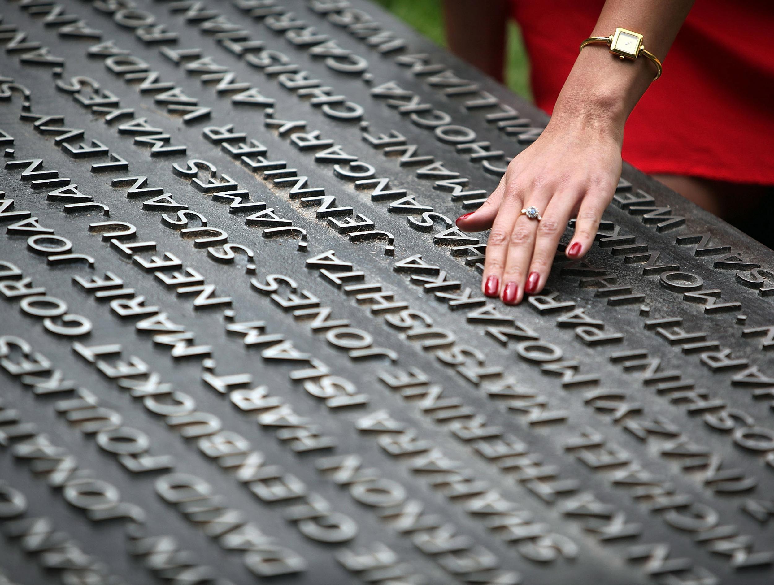 Saba Mozakka, whose mother was killed in the 7 July 2005 attacks, places her hand on the Hyde Park memorial plaque, which shows the names of all those who lost their lives