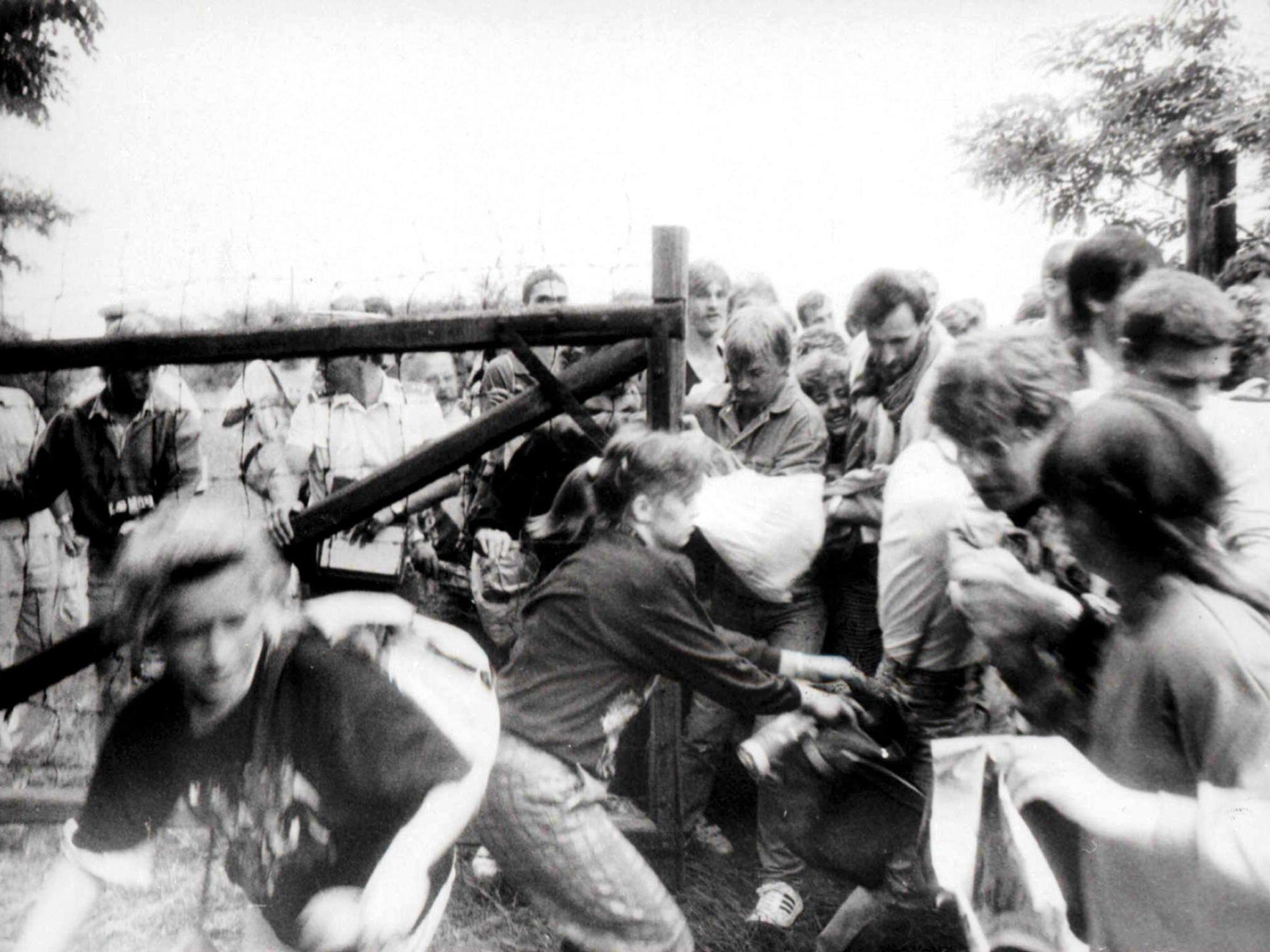 East German citizens break through a gate of the fence, separating Hungary and Austria, near Sopron during the Pan-European Picnic on 19 August 1989