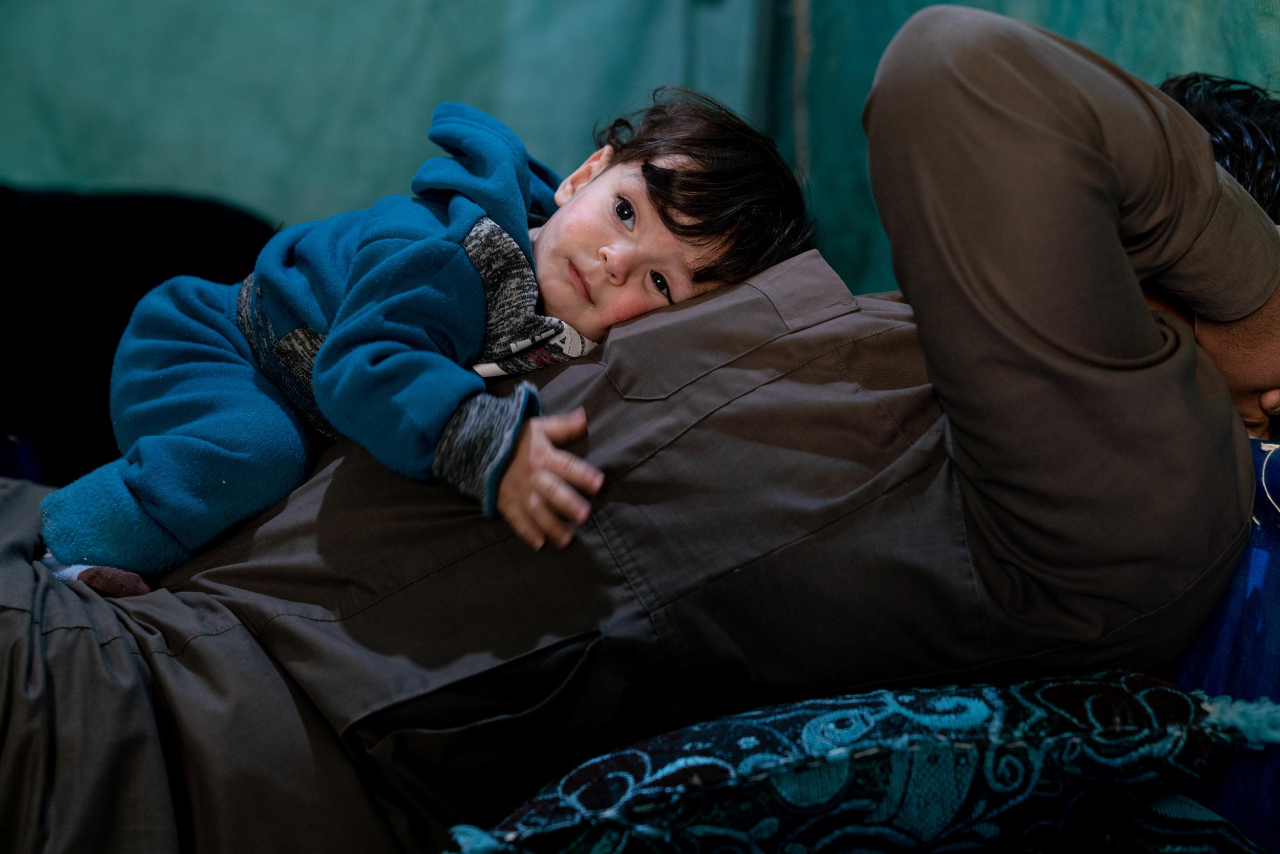 Ali, two, rests on his father’s chest. His family are Syrian refugees and came to Jordan six years ago. Ali has just received his winter clothing kit from Unicef and its partner Mateen.