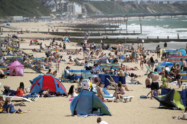 People enjoy the sunshine on the beach in Bournemouth, Dorset as temperatures are set to rise over the weekend