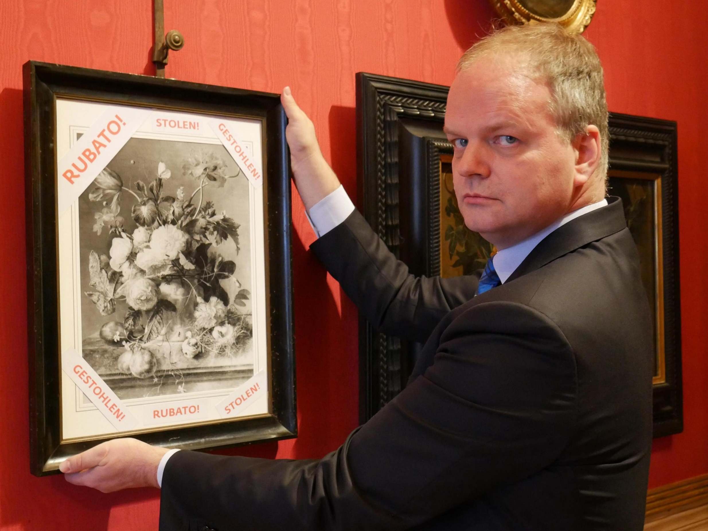 Uffizi Gallery director Eike Schmidt with a black and white copy of 'Vase of Flowers' by Dutch artist Jan van Huysum