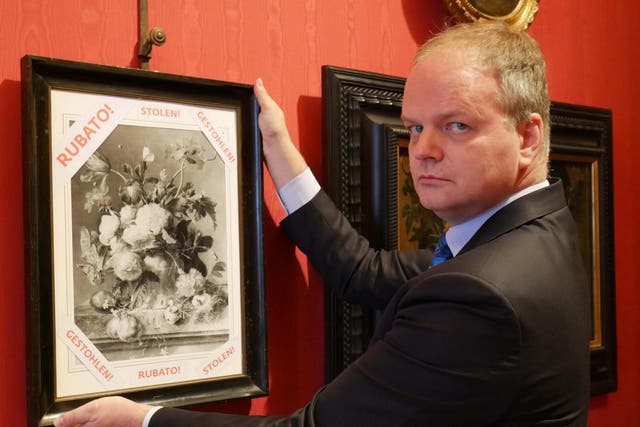 Uffizi Gallery director Eike Schmidt with a black and white copy of 'Vase of Flowers' by Dutch artist Jan van Huysum