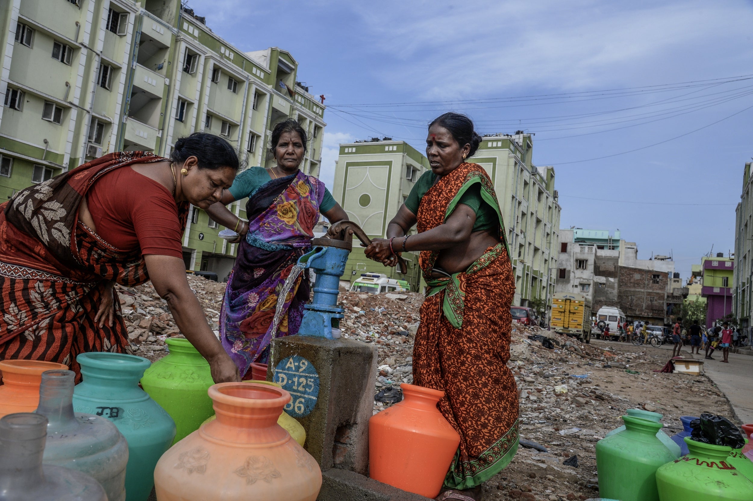 Residents of a housing complex in the city of Chennai fill water from a pump on 29 June