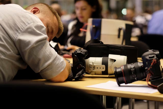 A journalist takes a break during a long night of negotiation at the special European Council summit in Brussels