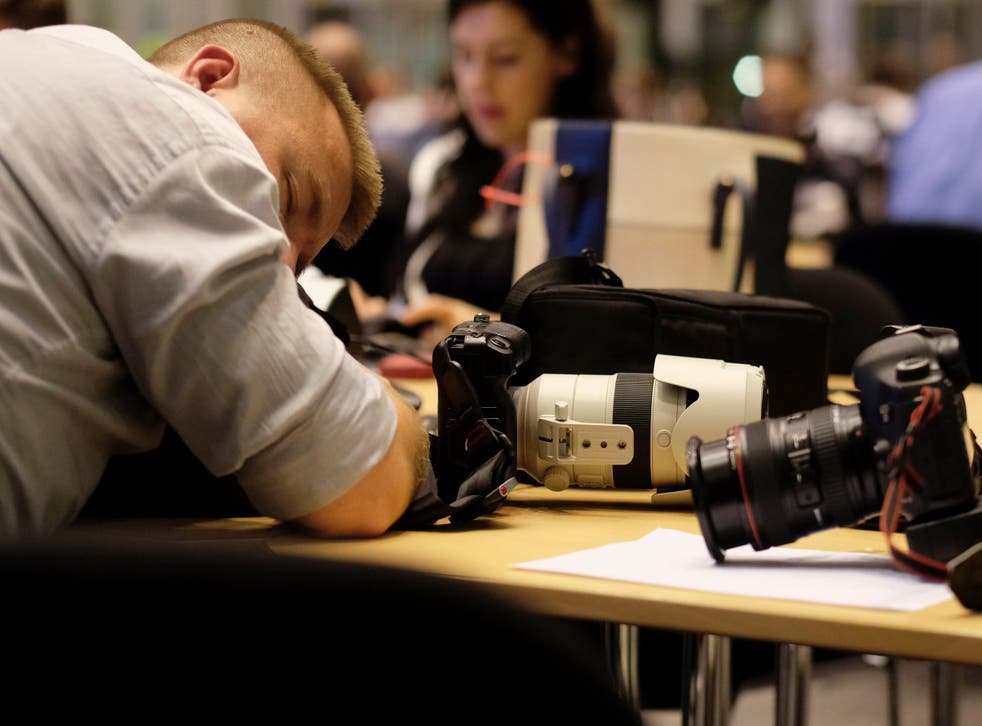 A journalist takes a break during a long night of negotiation at the special European Council summit in Brussels