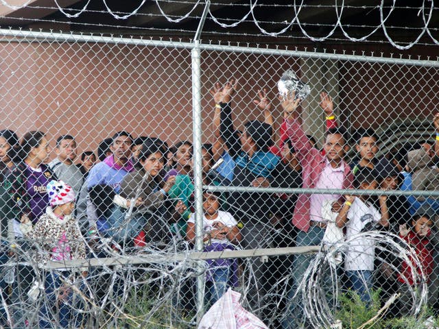 Central Americans wait for food in a pen near El Paso, Texas