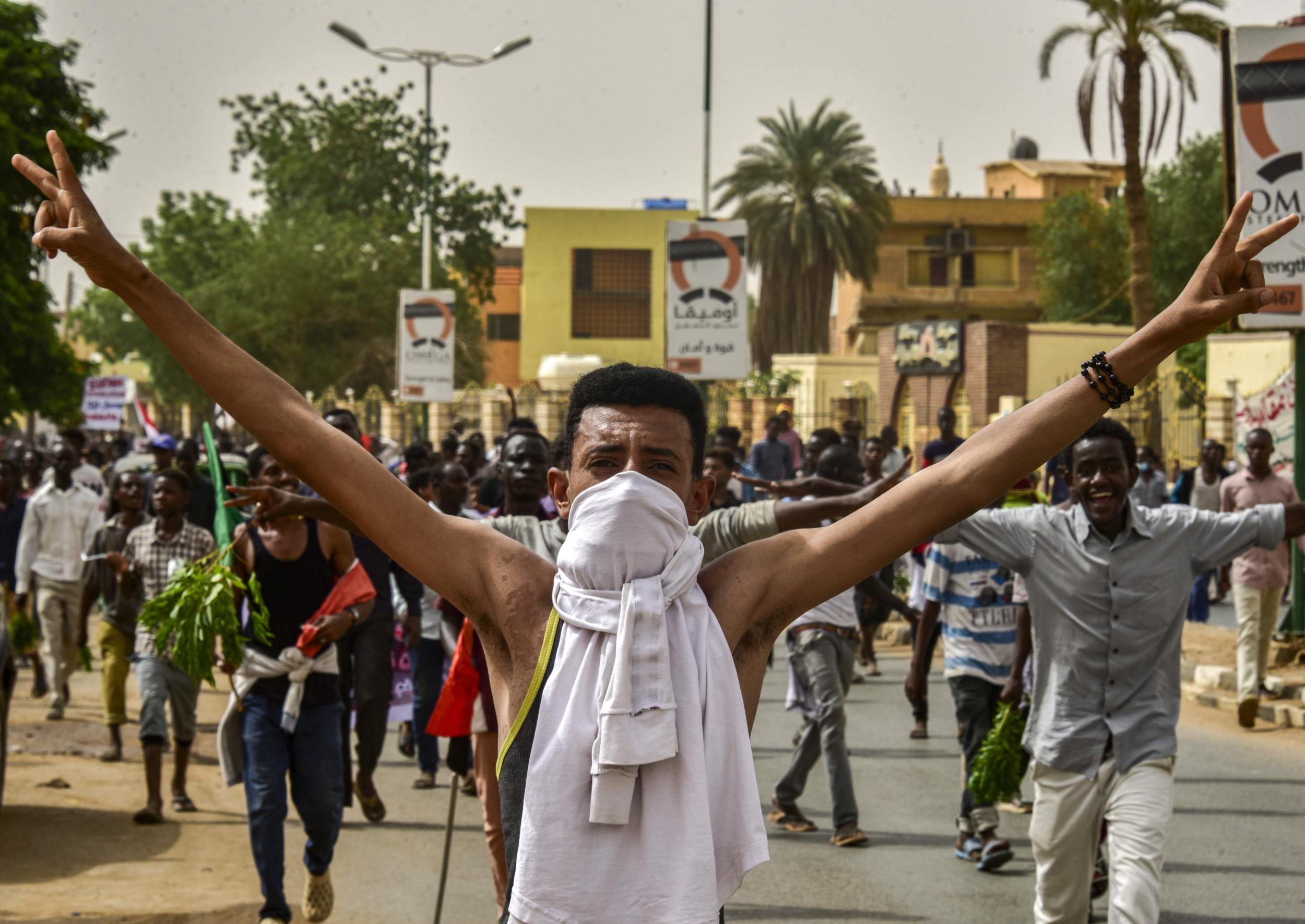A Sudanese protester flashes a victory sign while marching with others in a mass demonstration against the country's ruling generals in Omdurman on June 30