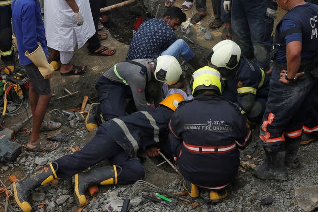 Rescue workers search for survivors after the collapse of a wall in Mumbai on Tuesday
