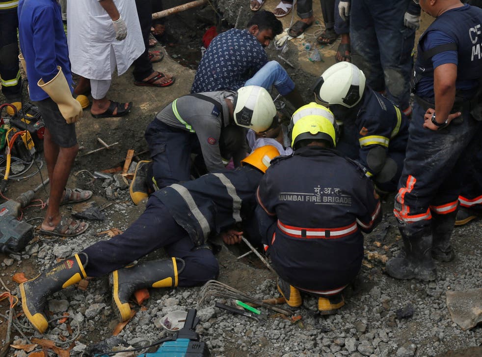 Rescue workers search for survivors after the collapse of a wall in Mumbai on Tuesday