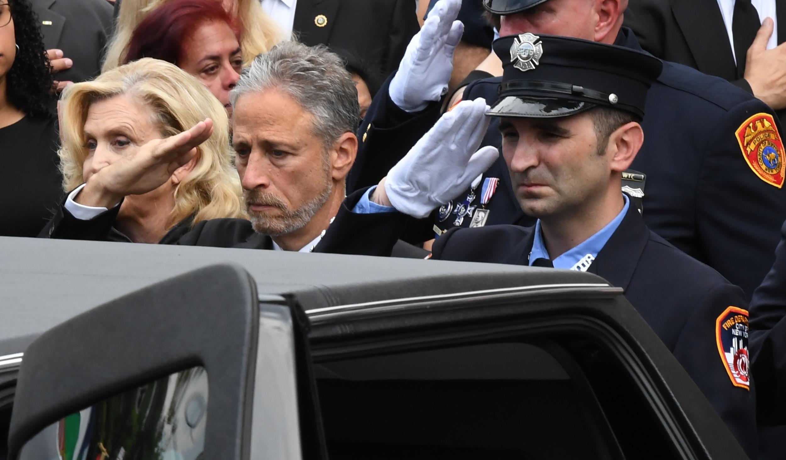 Jon Stewart and New York Representative Carolyn Maloney attend the funeral mass at Immaculate Conception Church in Astoria, Queens
