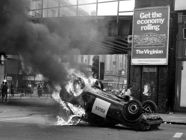 A police car blazes at the corner of Atlantic and Brixton Road during the 1981 riots