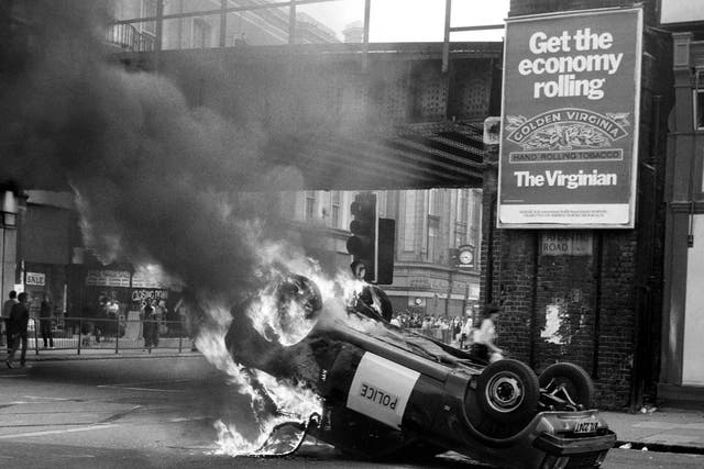 A police car blazes at the corner of Atlantic and Brixton Road during the 1981 riots
