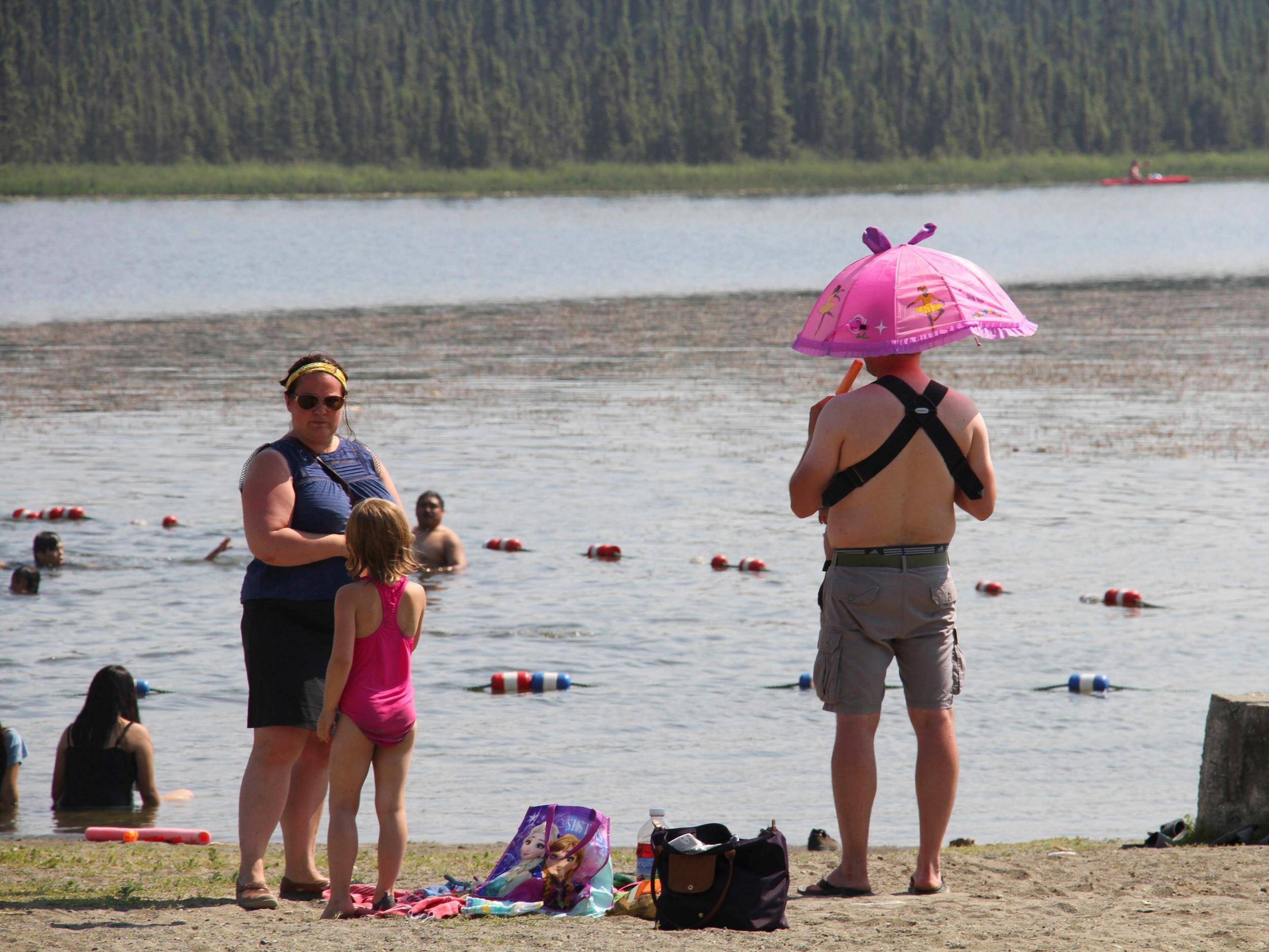 Parasols, ice lollies and inflatable pool toys were deployed at Goose Lake, Anchorage, Alaska as residents used to cooler temperatures tried to beat record breaking heat