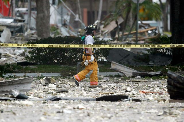 A firefighter walks through the remains of a building after an explosion in Plantation, Florida