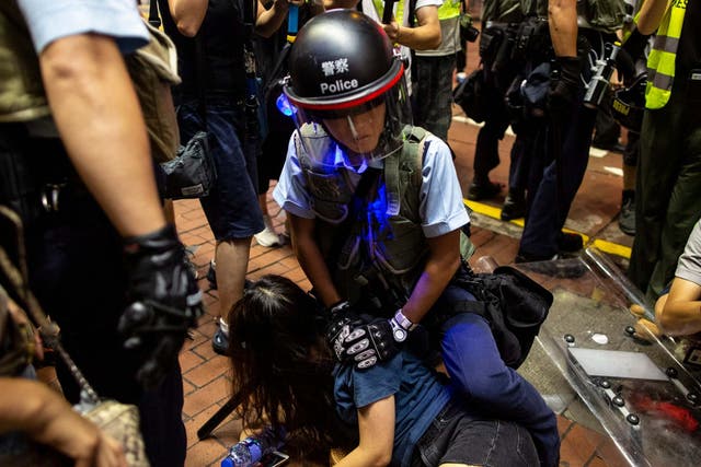 A riot police officer detains anti-extradition bill protester on Sunday