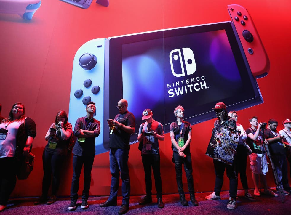 Game enthusiasts and industry personnel walk past the Nintendo Switch exhibit during the Electronic Entertainment Expo E3 at the Los Angeles Convention Center
