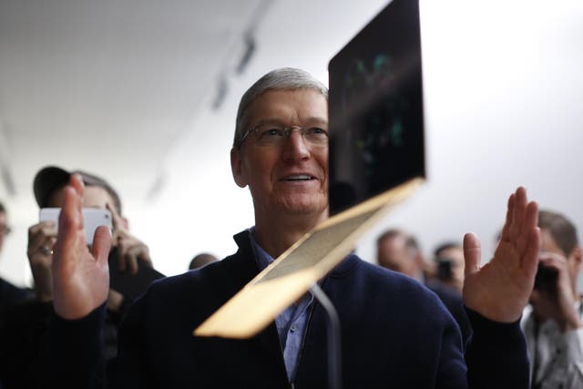 Apple CEO Tim Cook stands in front of an MacBook on display after an Apple special event at the Yerba Buena Center for the Arts on March 9, 2015 in San Francisco, California
