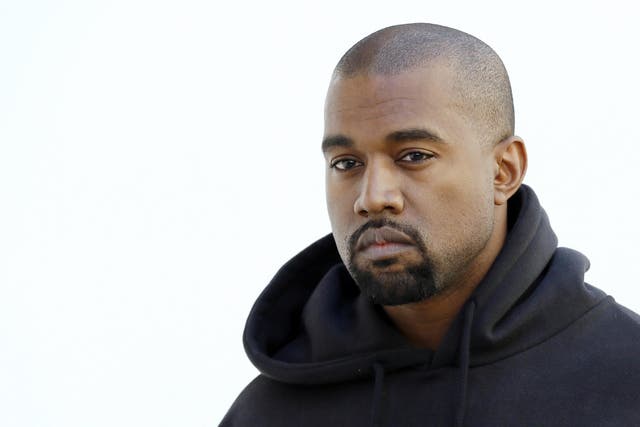 Kanye West poses before Christian Dior 2015-2016 fall/winter ready-to-wear collection fashion show on March 6, 2015 in Paris.