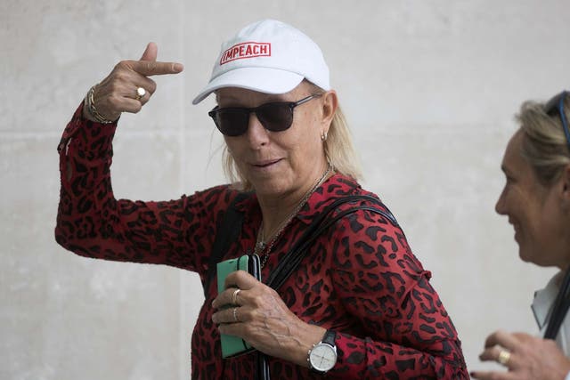 Former tennis professional Martina Navratilova points to her cap