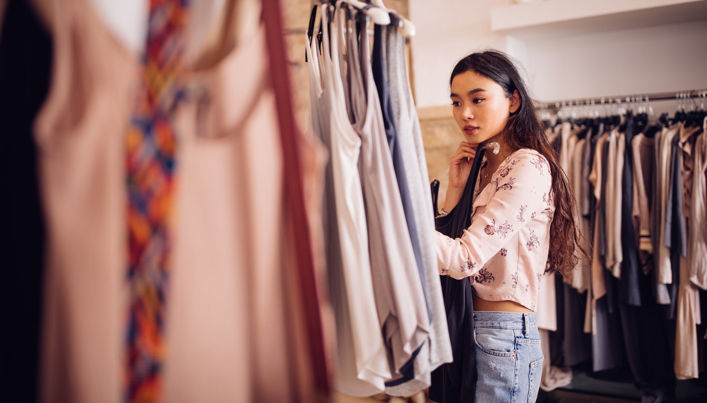 Woman shopping for clothes inside a clothing store